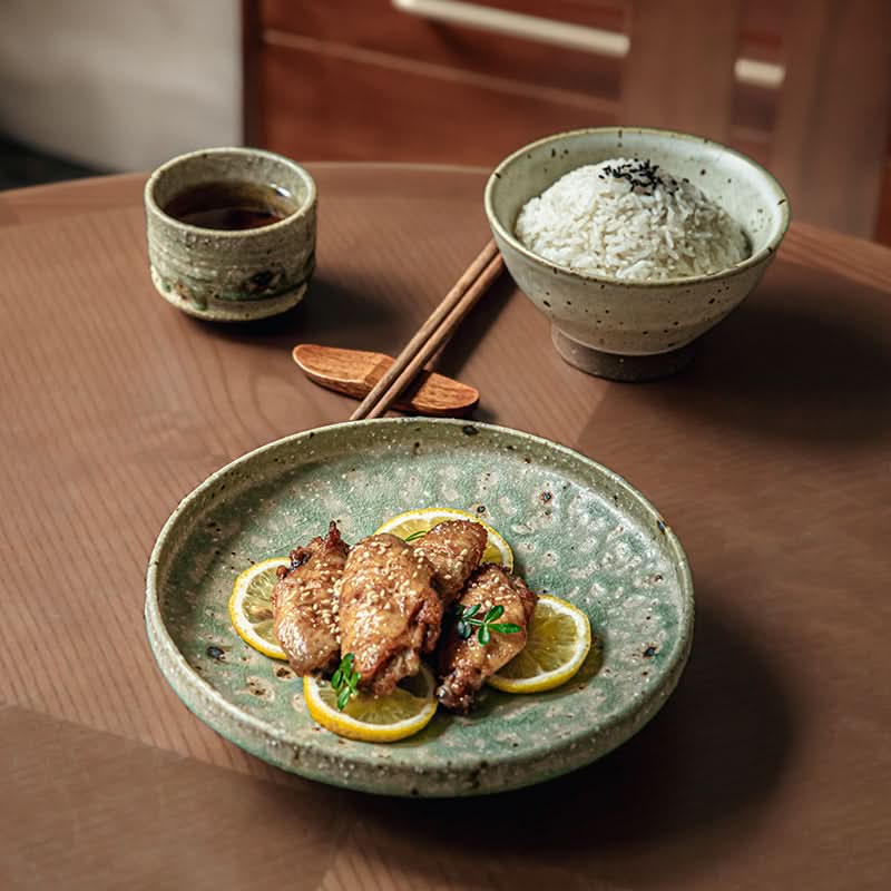 Artisan Green Dinnerware plate with roasted chicken wings and lemon slices.